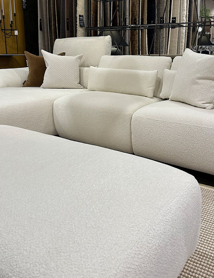 White sectional Rom sofa with cushions and a coffee table.