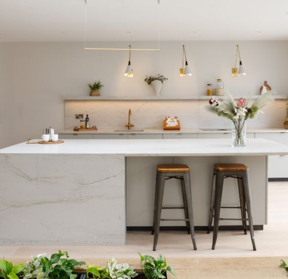 Modern fitted kitchen with bar stools and natural light.