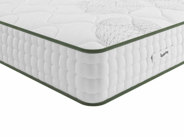 Corner view of a white vegan mattress with green piping.