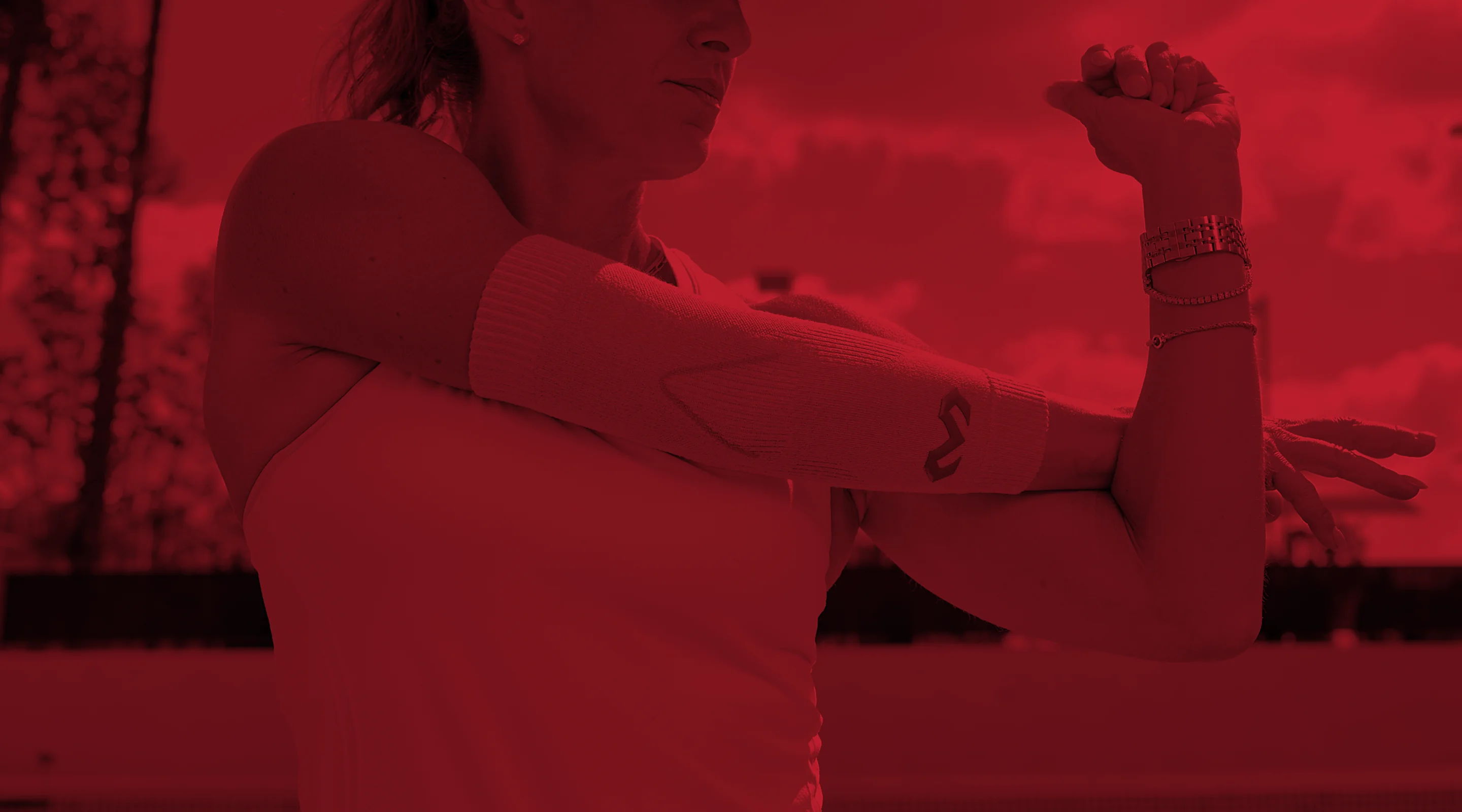Person stretching their arm against a red-tinted background.