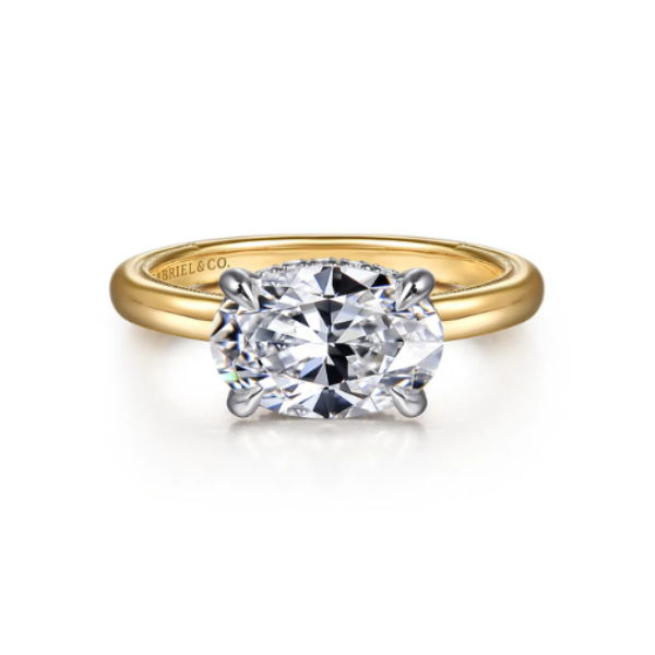 A gold ring featuring a large, sparkling diamond centerpiece.
