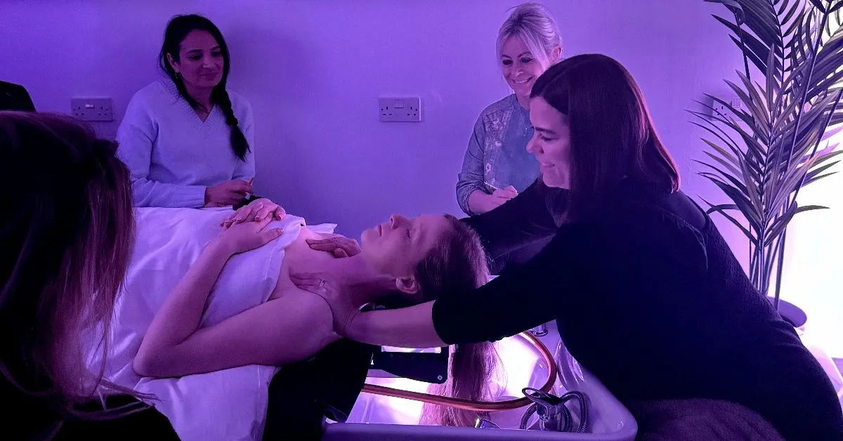 A woman receiving a Japanese head spa treatment with others observing in a spa setting.