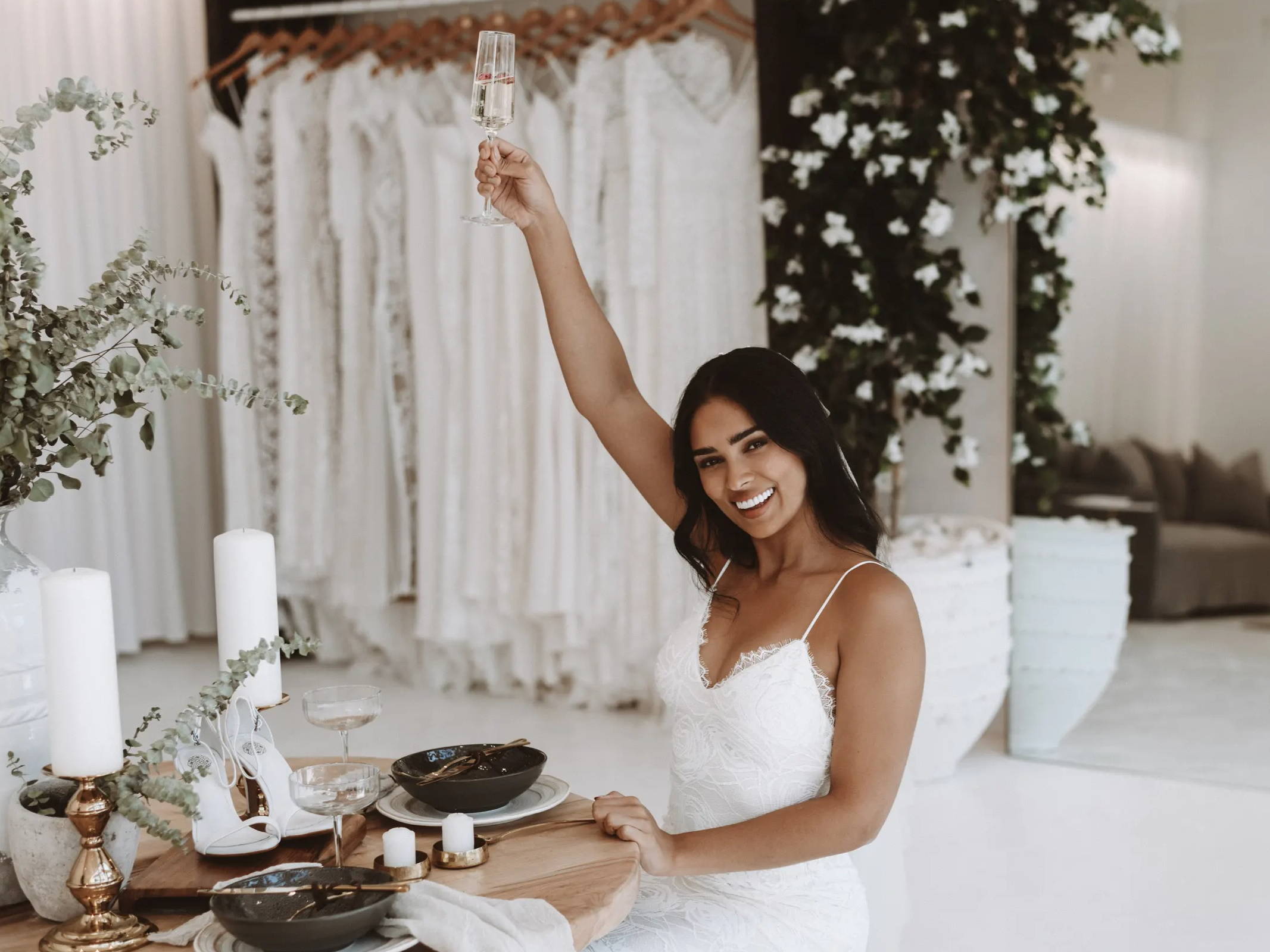 Bride sitting holding up her champagne at the Grace Loves Lace bridal salon