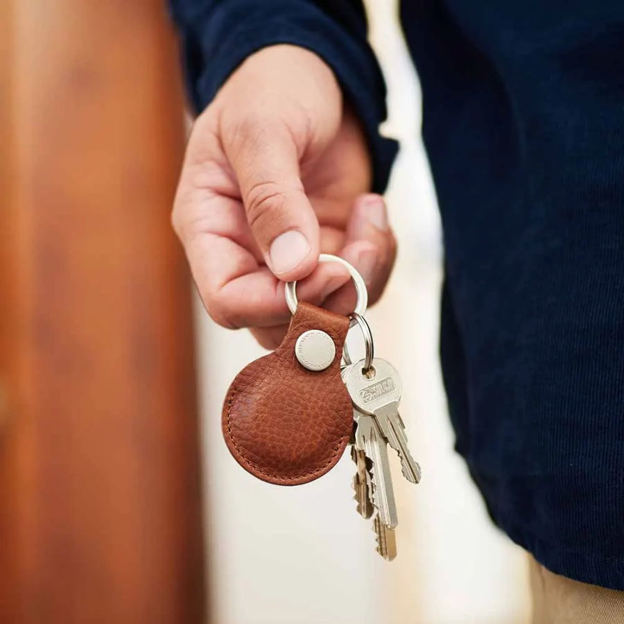 Eine Hand hält einen Airtag Schlüsselanhänger von Goodwilhelm