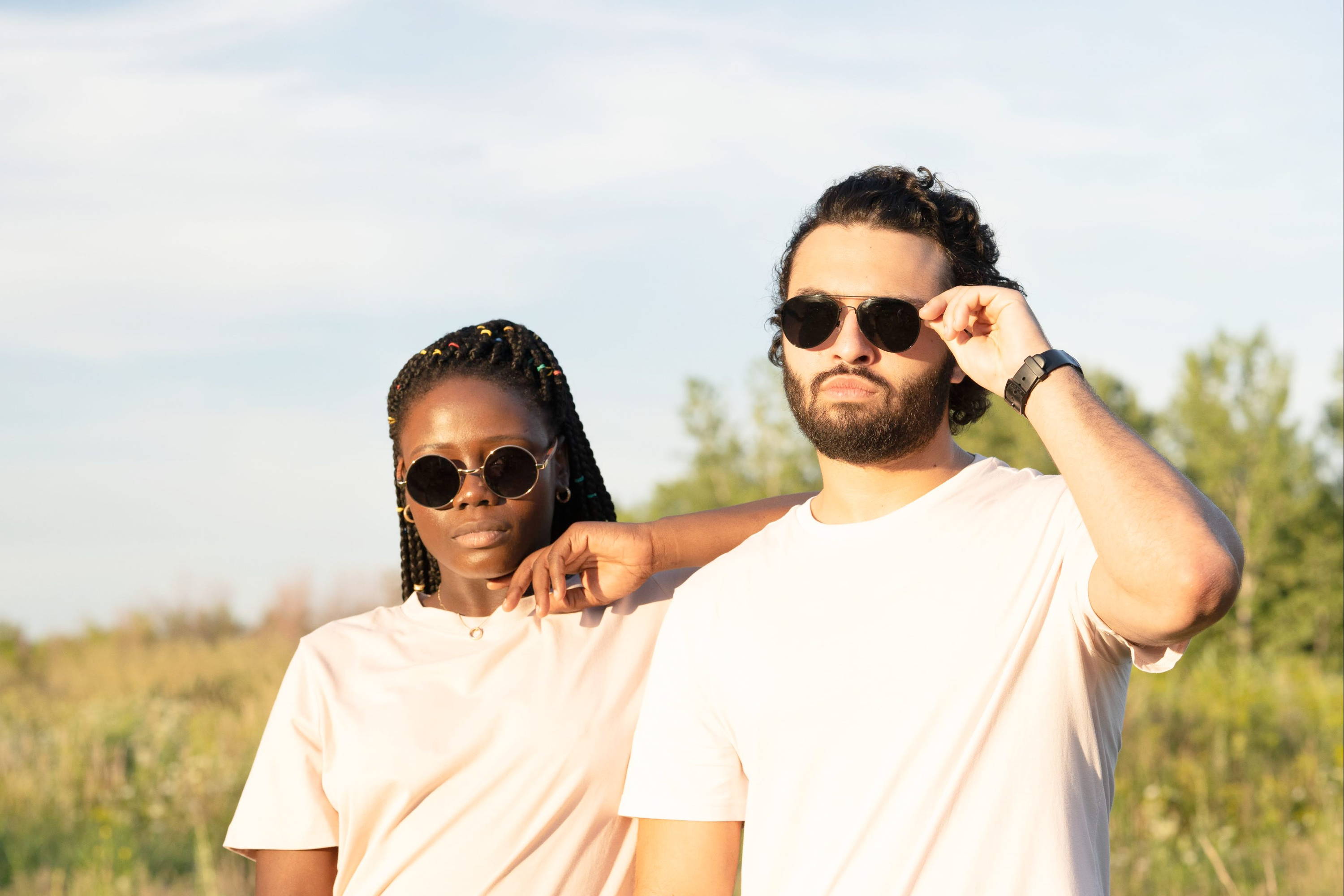 Woman with square face wearing round wooden sunglasses leaning on Man with square face shape wearing aviator wooden sunglasses 