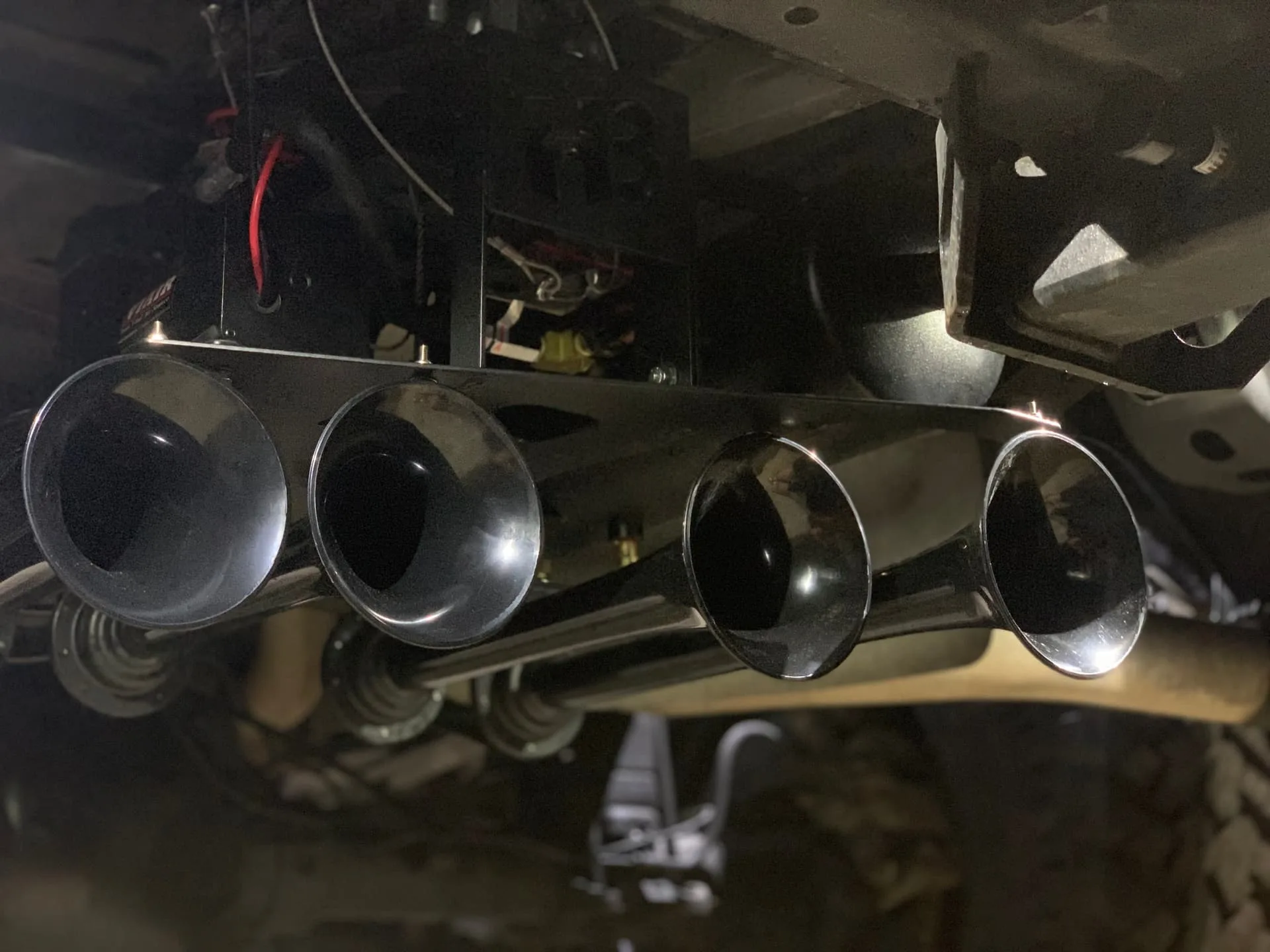 Four black train horn bells mounted beneath truck