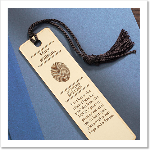 brass bookmark engraved with a fingerprint and inscription