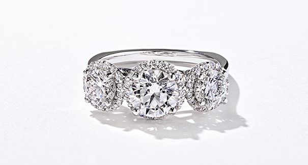 Custom diamond three stone ring with a halo of diamonds around each ring