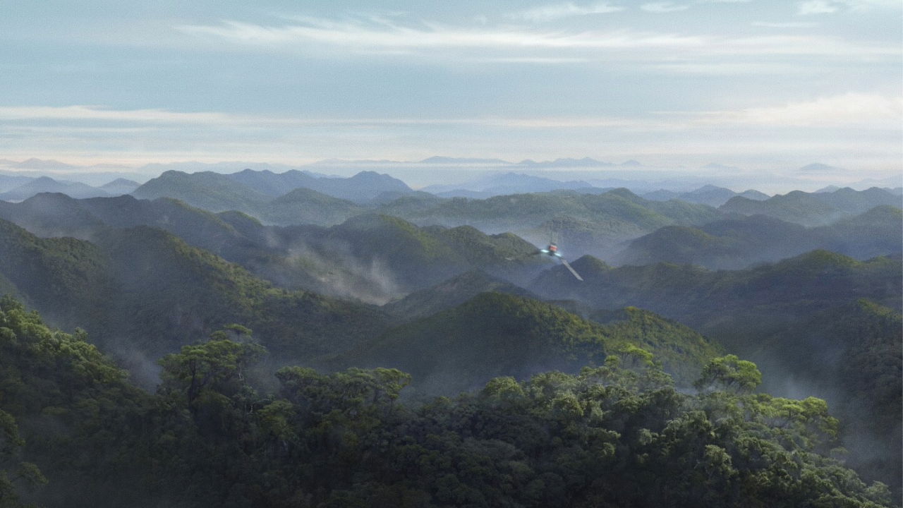 Lush green mountains under a cloudy sky with misty valleys.