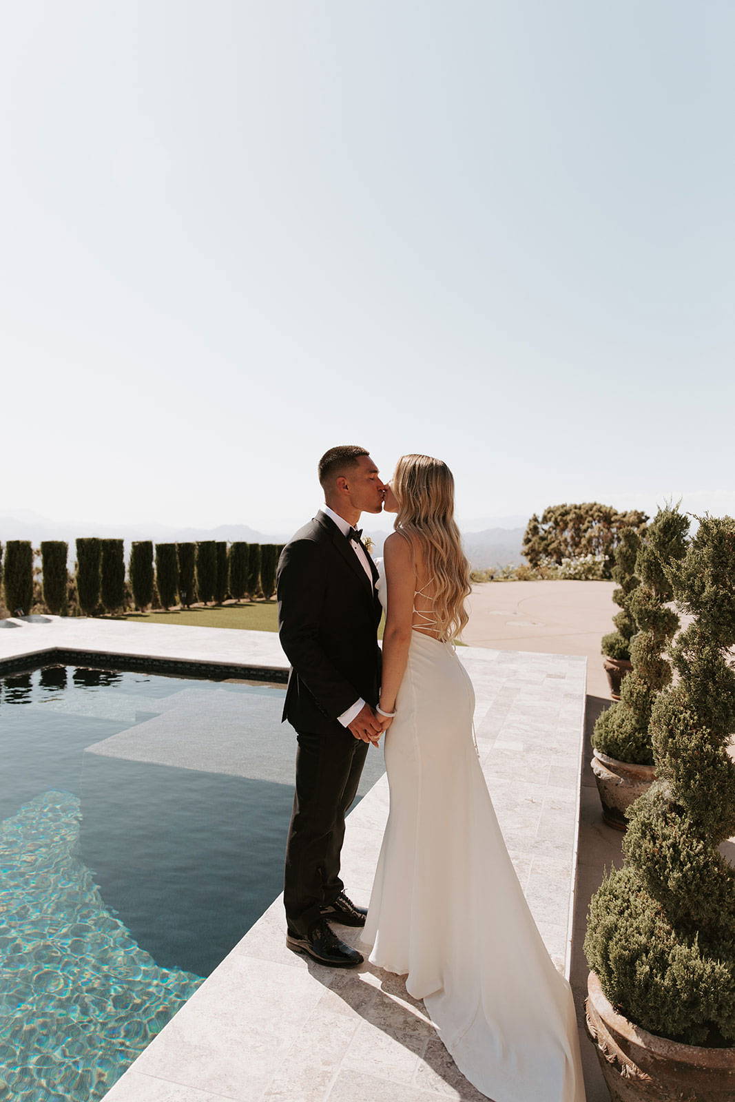 Grace Bride y su nuevo marido compartiendo un beso cerca de la zona de la piscina