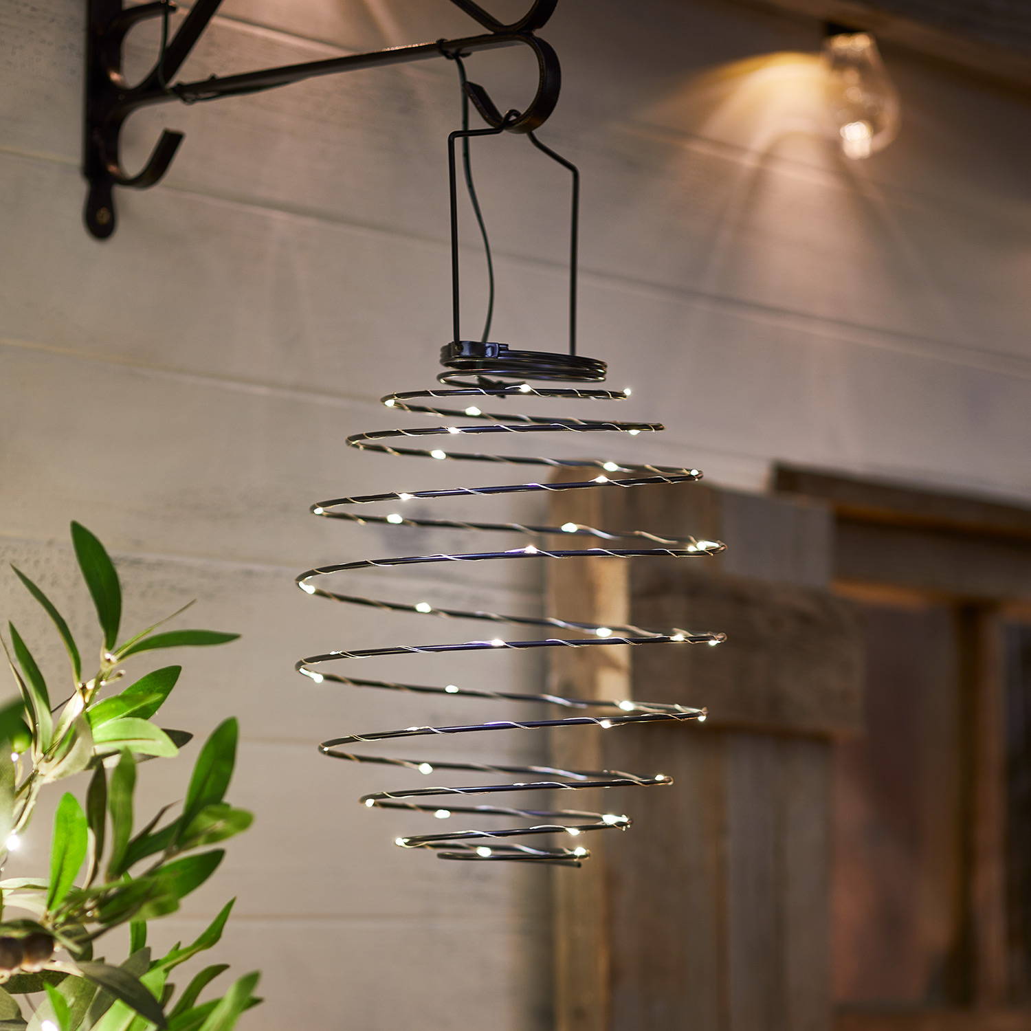 Carlton spiral solar lantern hung in garden and illuminated