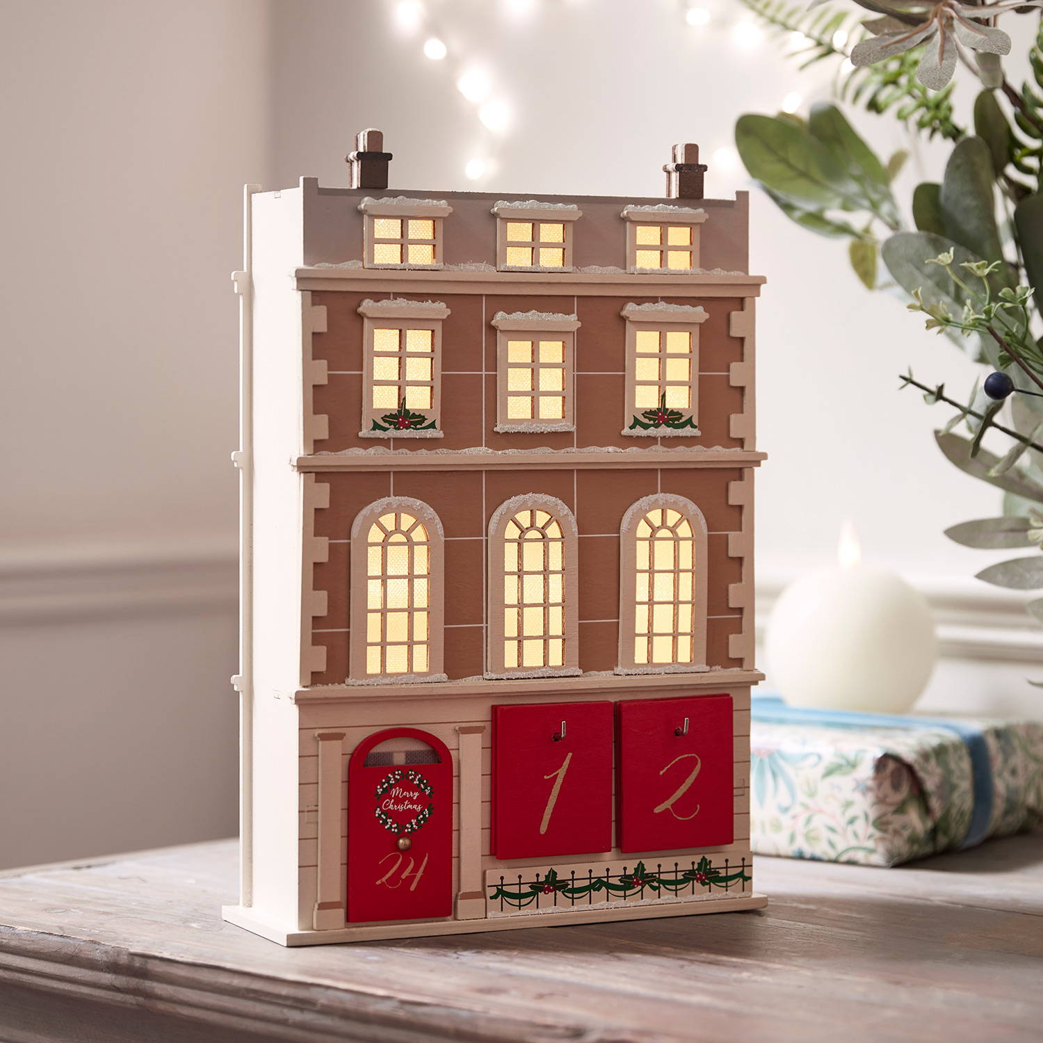 A wooden townhouse advent calendar placed on a living room table