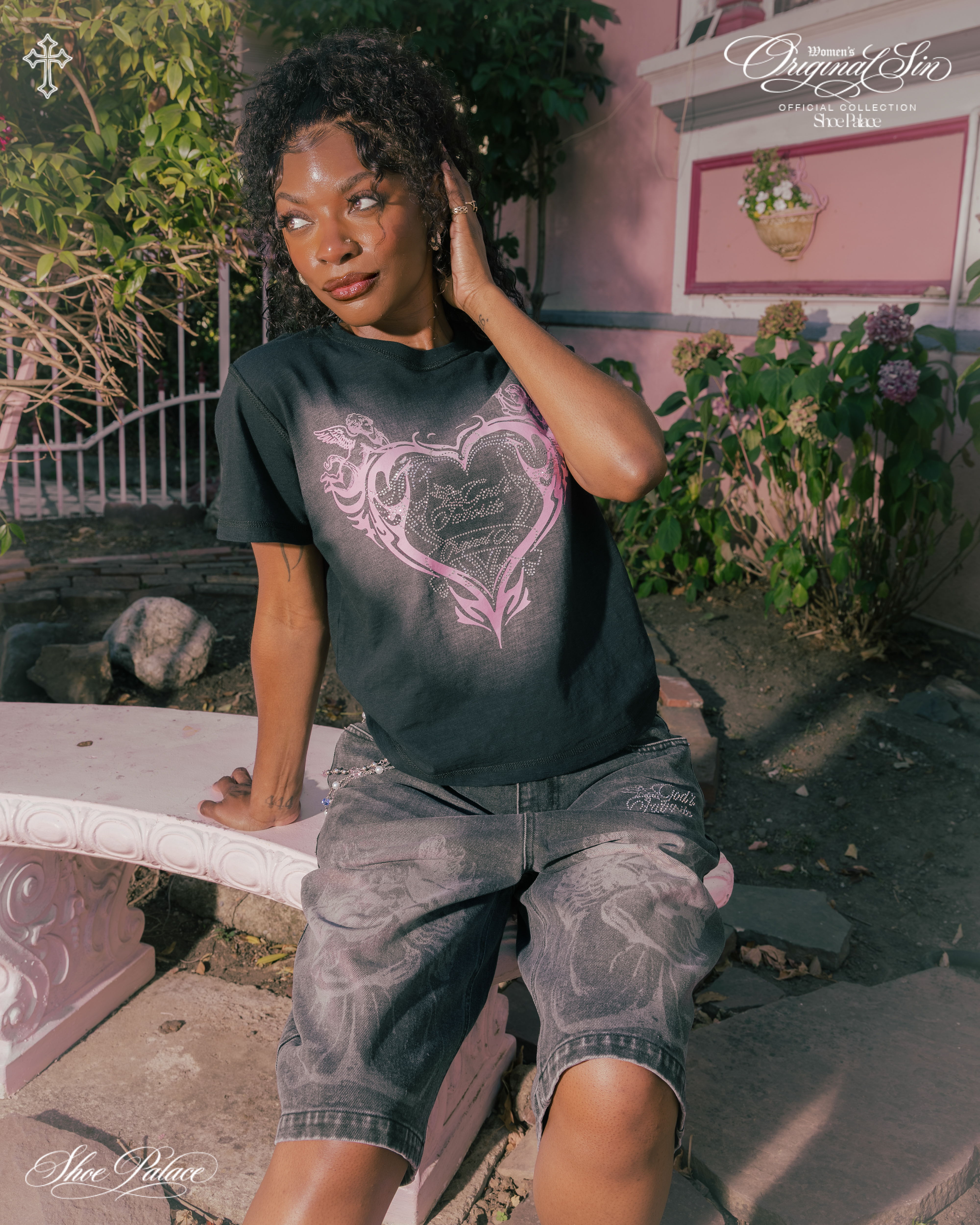 Person sitting on a bench wearing a black shirt and shorts, smiling.