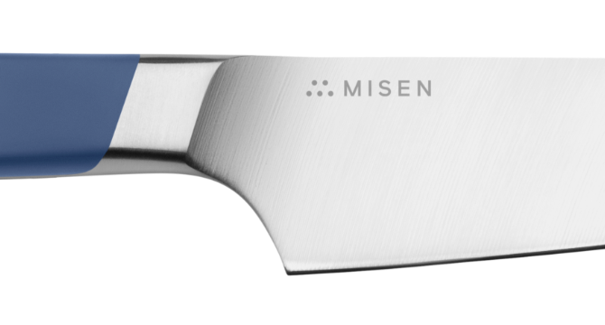 Close view of Blue Misen Utility Knife where handle meets the blade, showing a bolster sloped for a comfortable grip.