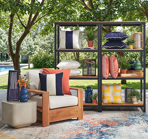 Outdoor seating area with shelves, cushions, and greenery in the background.