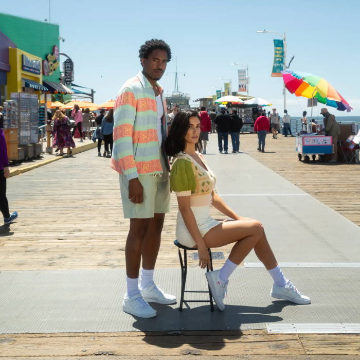 2 models wearing white adidas forum in middle of pier