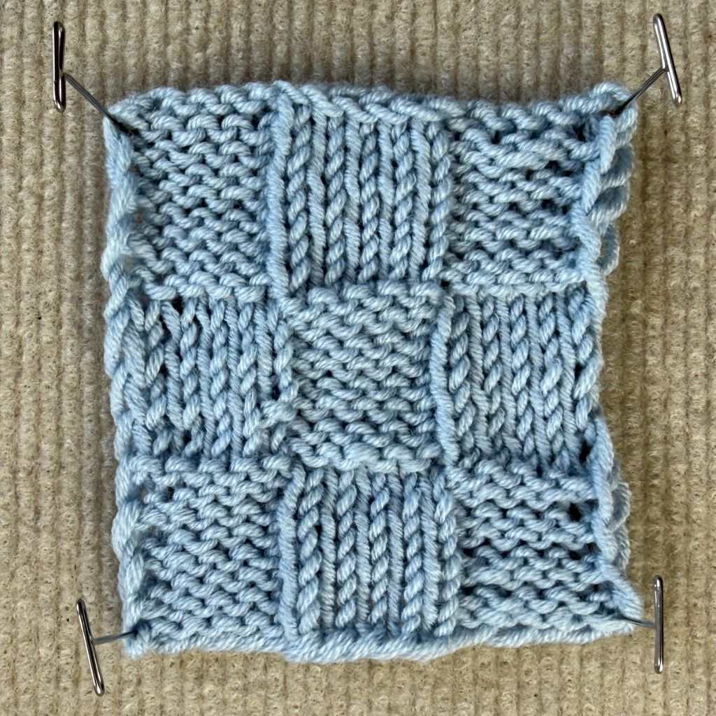 Maschenprobe im Schachbrettmuster aus blauem Garn.