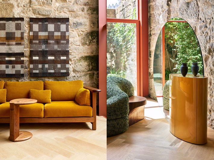 Modern living room with yellow sofa, green chair, and stone walls.