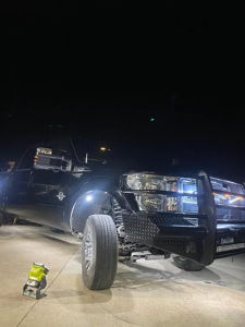 Troy's black 2012 Ford F250 at night with front brush guard and LED rock lights