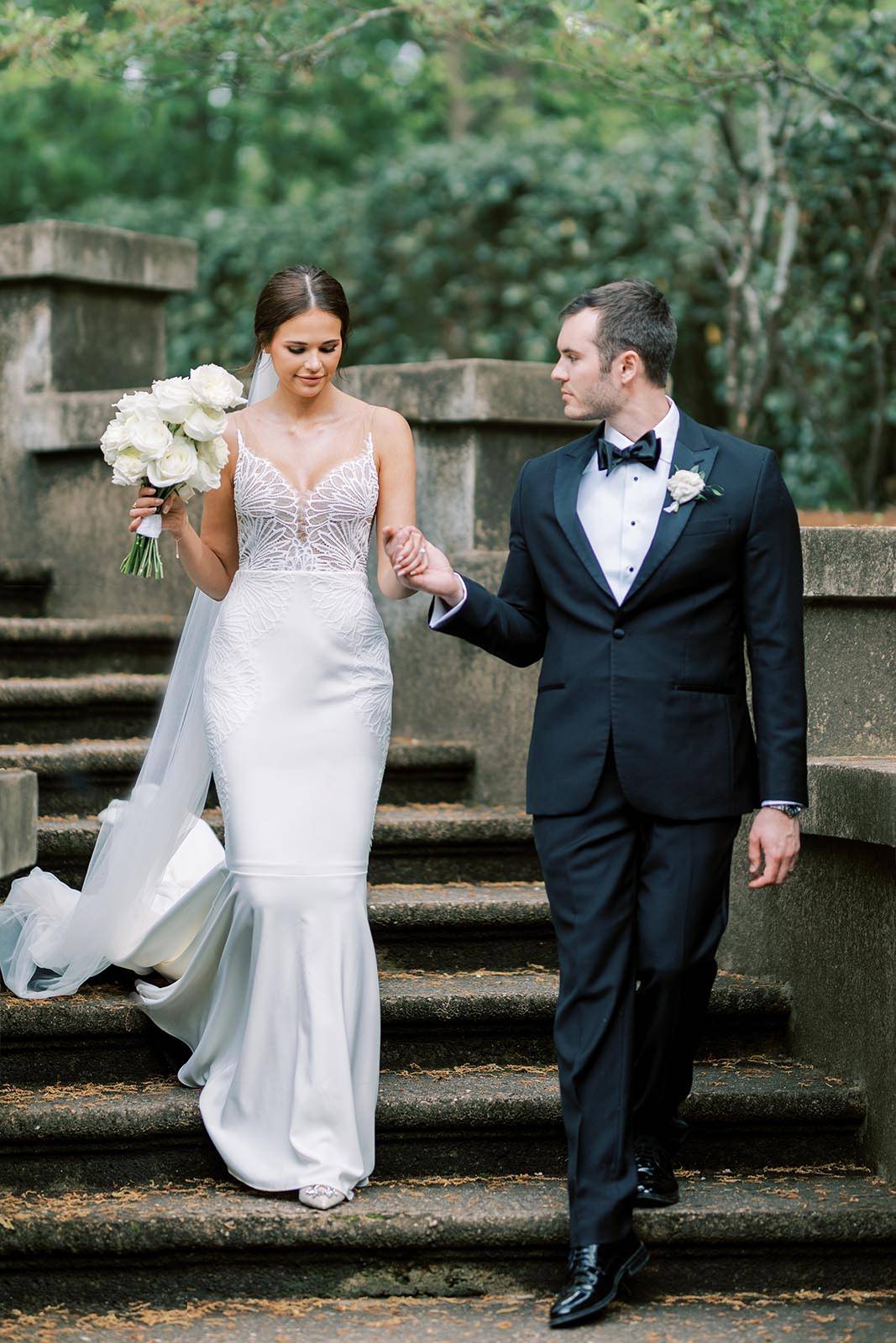 Bride and Groom, ascending a grand staircase, hand in hand