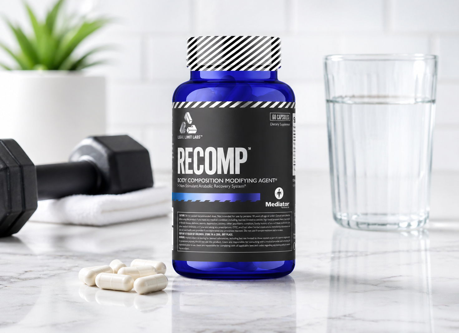 A bottle of body composition supplement beside a glass of water and weights.