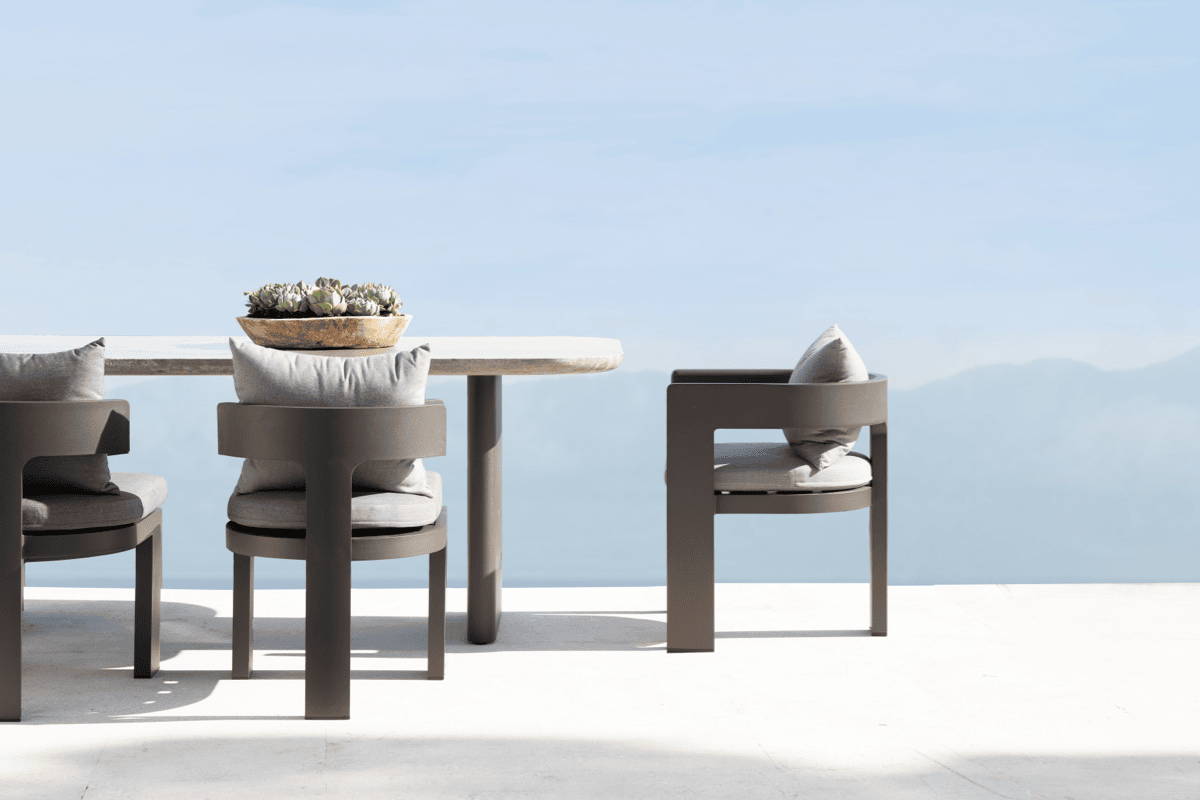 Outdoor dining set featuring uniquely curved dining chairs and soft edge table.