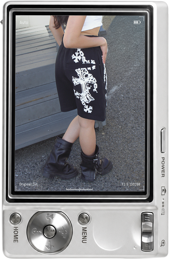Person wearing black shorts and boots, standing beside a vehicle.