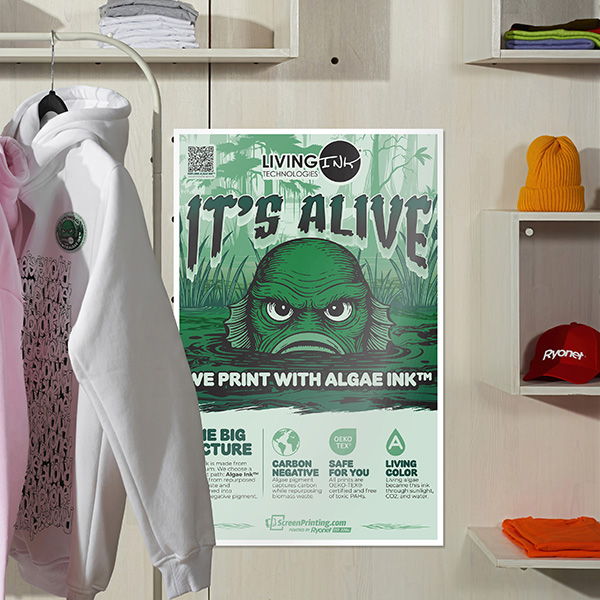 Living Ink Technologies poster displayed with a green swamp monster graphic in a store setting with clothing and hats.