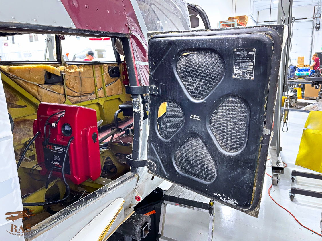 A vehicle door partially open in a workshop environment.