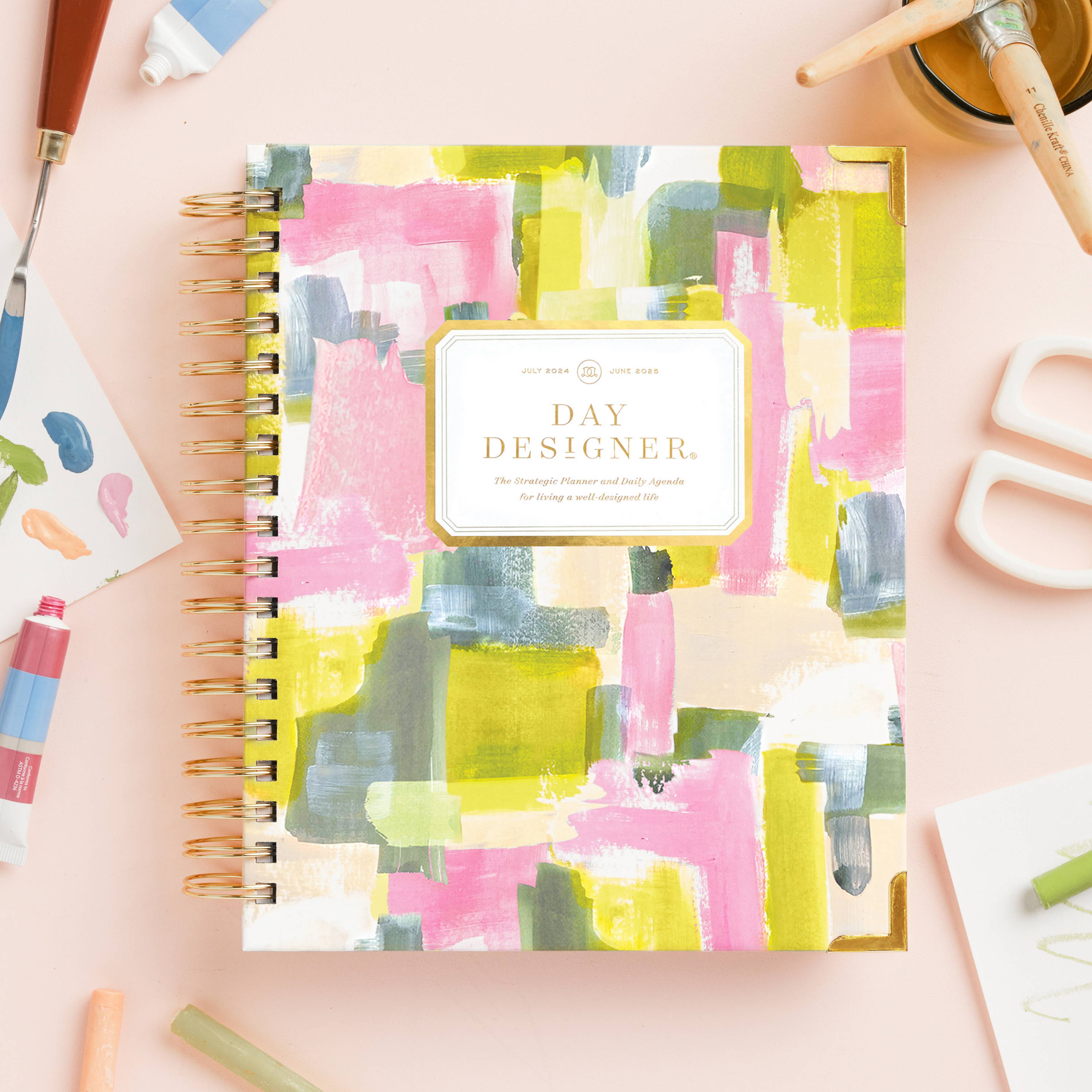 pink, yellow, and blue painterly swatches on closed book planner on beige background 