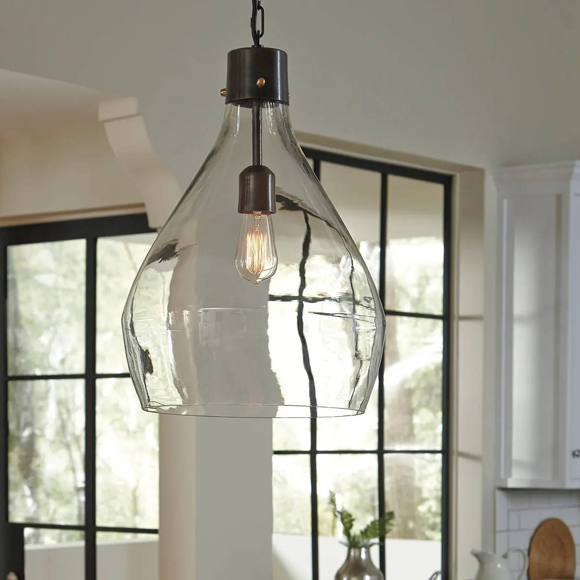 A translucent chandelier with lots of natural light flowing in from a nearby window.