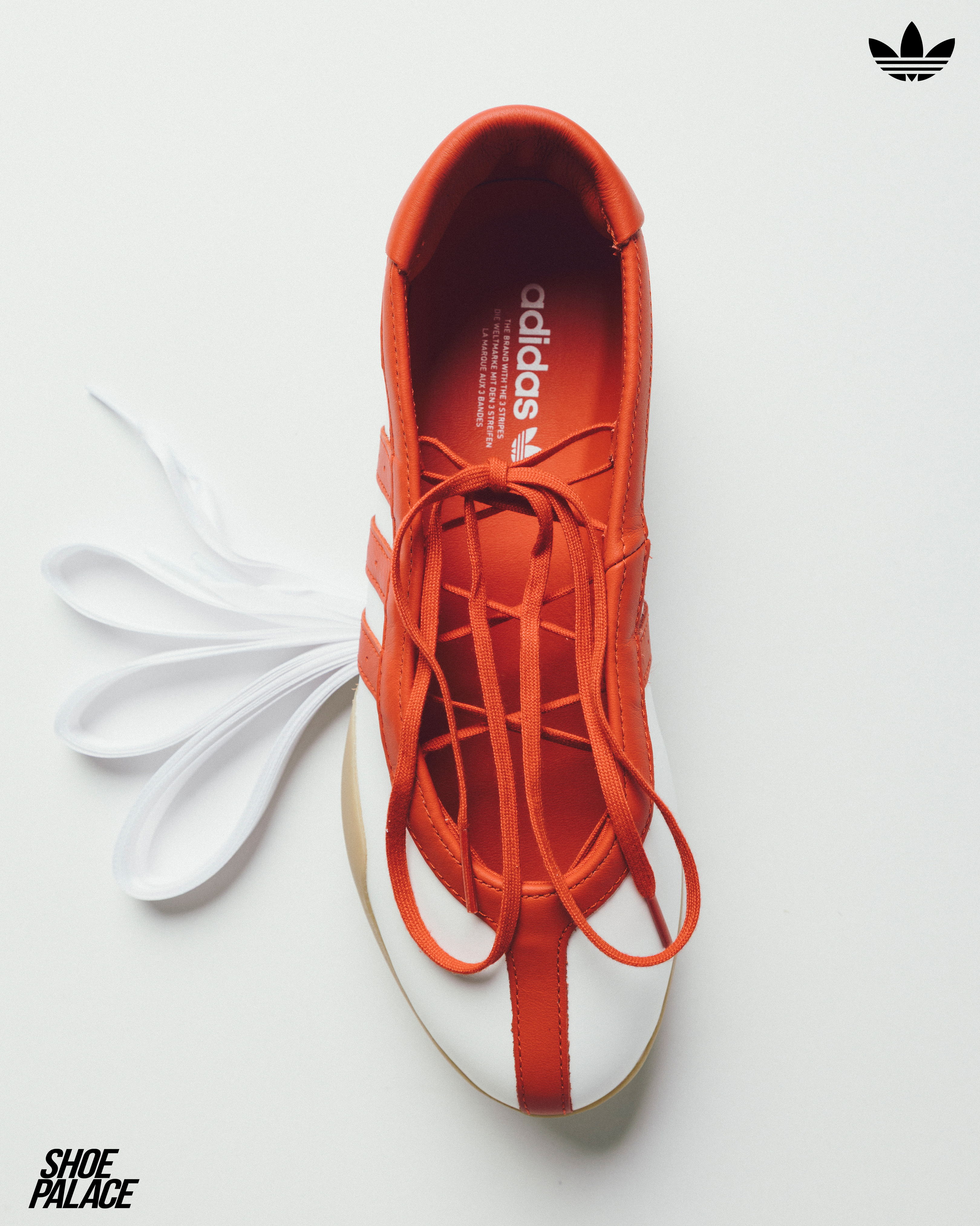 Red and white sneaker with laces and Adidas logo.