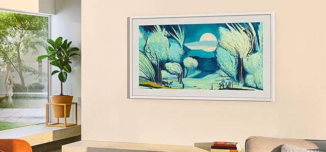 Frame TV showing a serene landscape with trees and a moon on the wall.