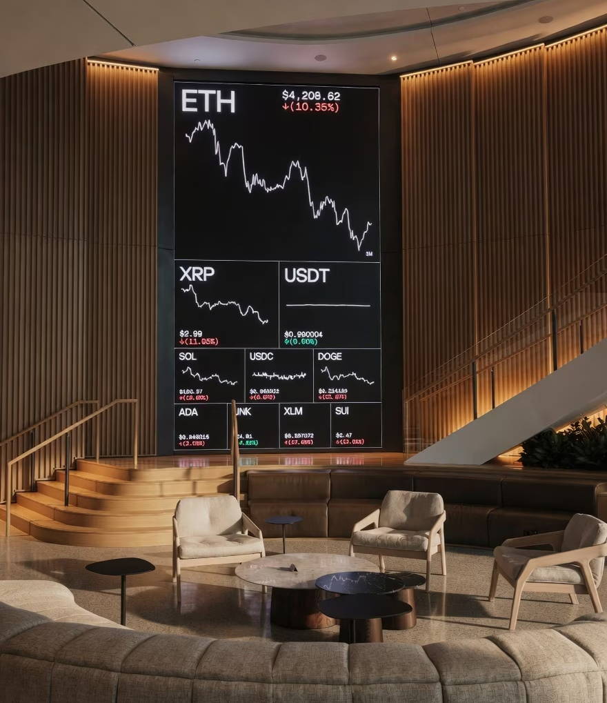 Modern lounge with cryptocurrency charts displayed on a large screen.