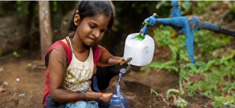 Girl collecting water from a tap in a rural setting.