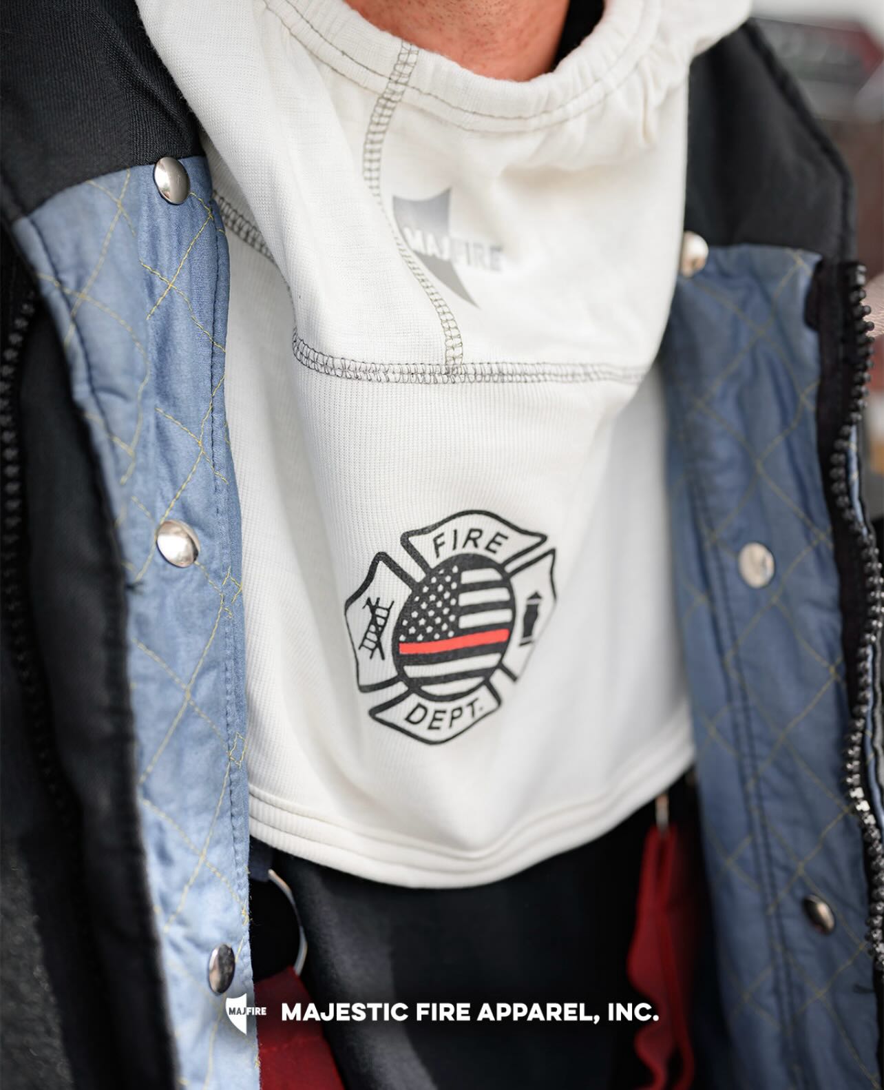 Person wearing a jacket with a fire department emblem on the shirt.