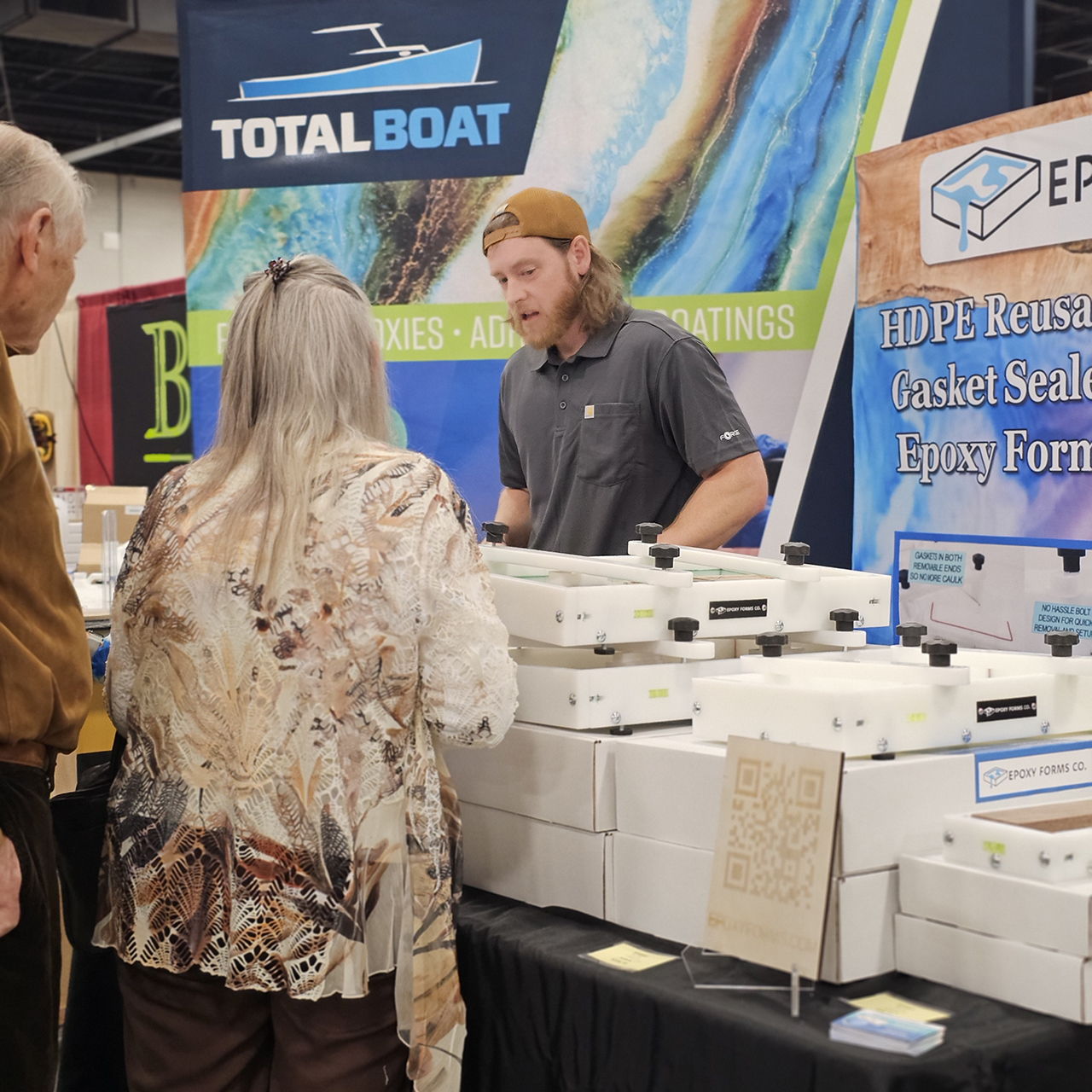 People engaging at a trade show booth with products displayed.