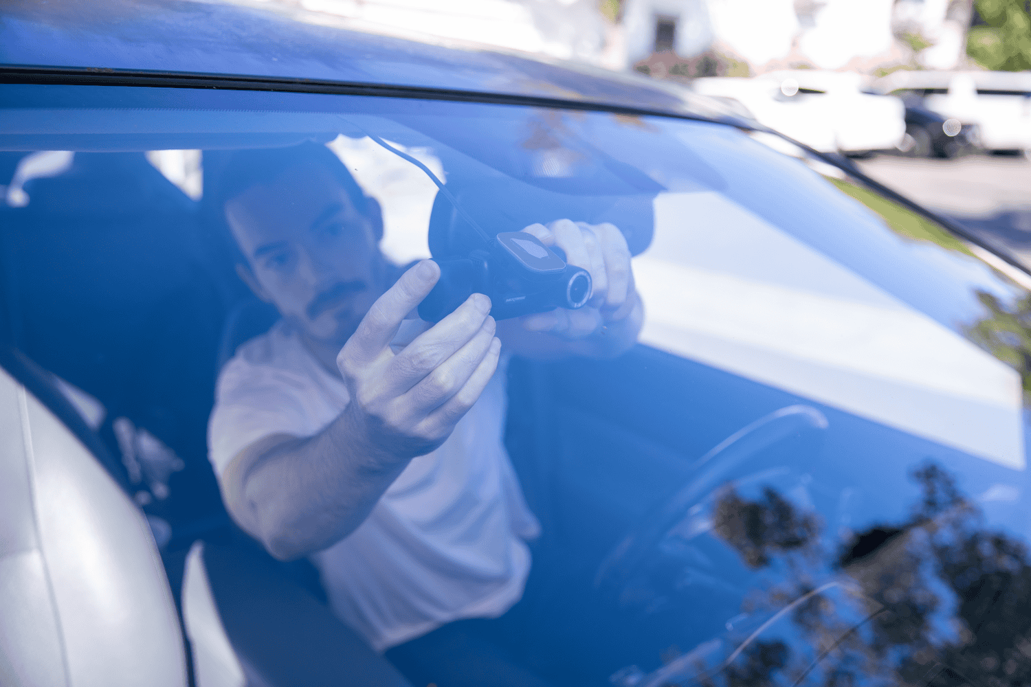 Man inside a car reaching out through the window.