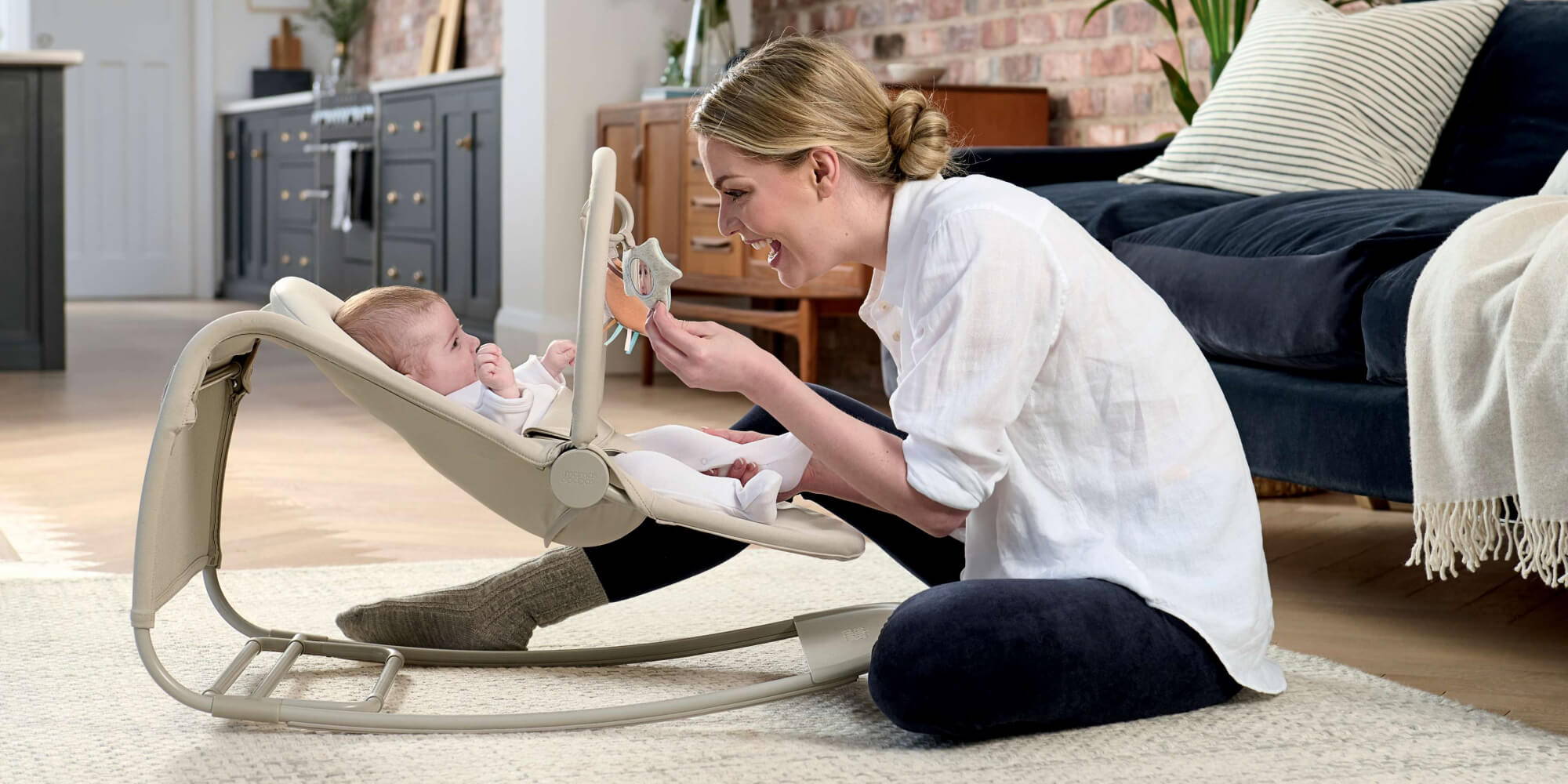 Mother playing with child in Mamas & Papas Tempo Rocker Bouncer