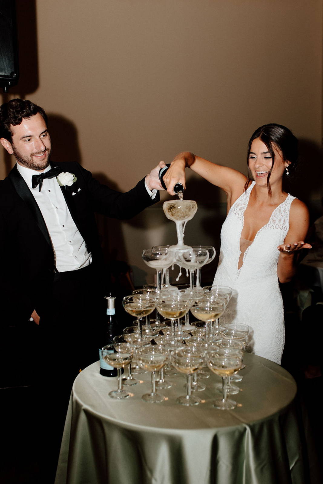 Bride and groom pouring champagne over glasses