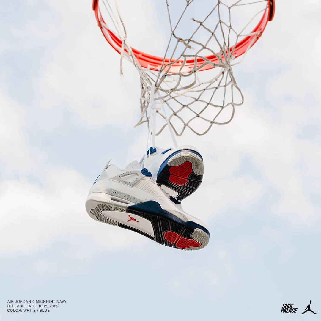 aj4 retro midnight navy hanging from a basketball hoop