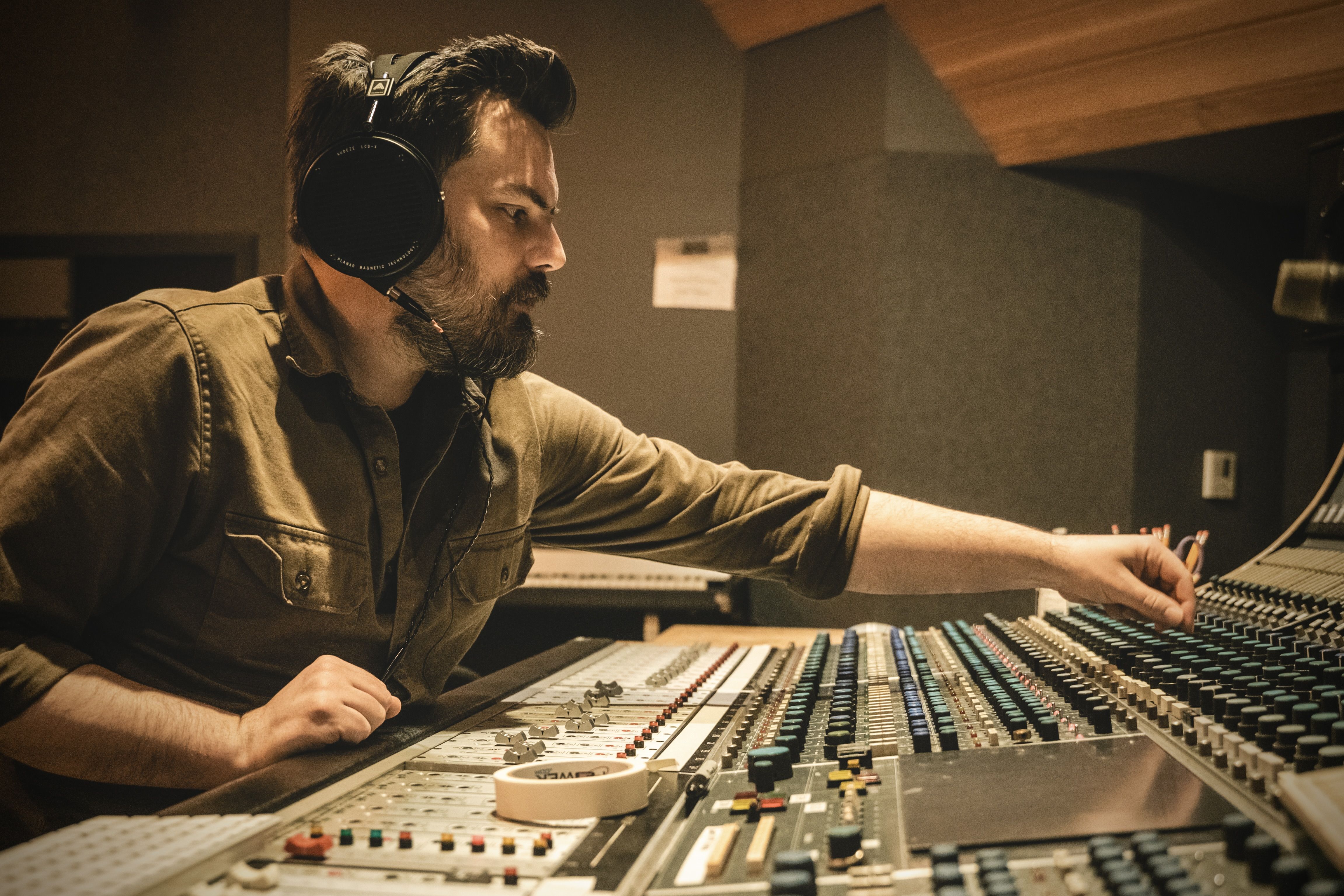 Mark Goodell adjusting Audeze LCD-X headphones in a recording studio.
