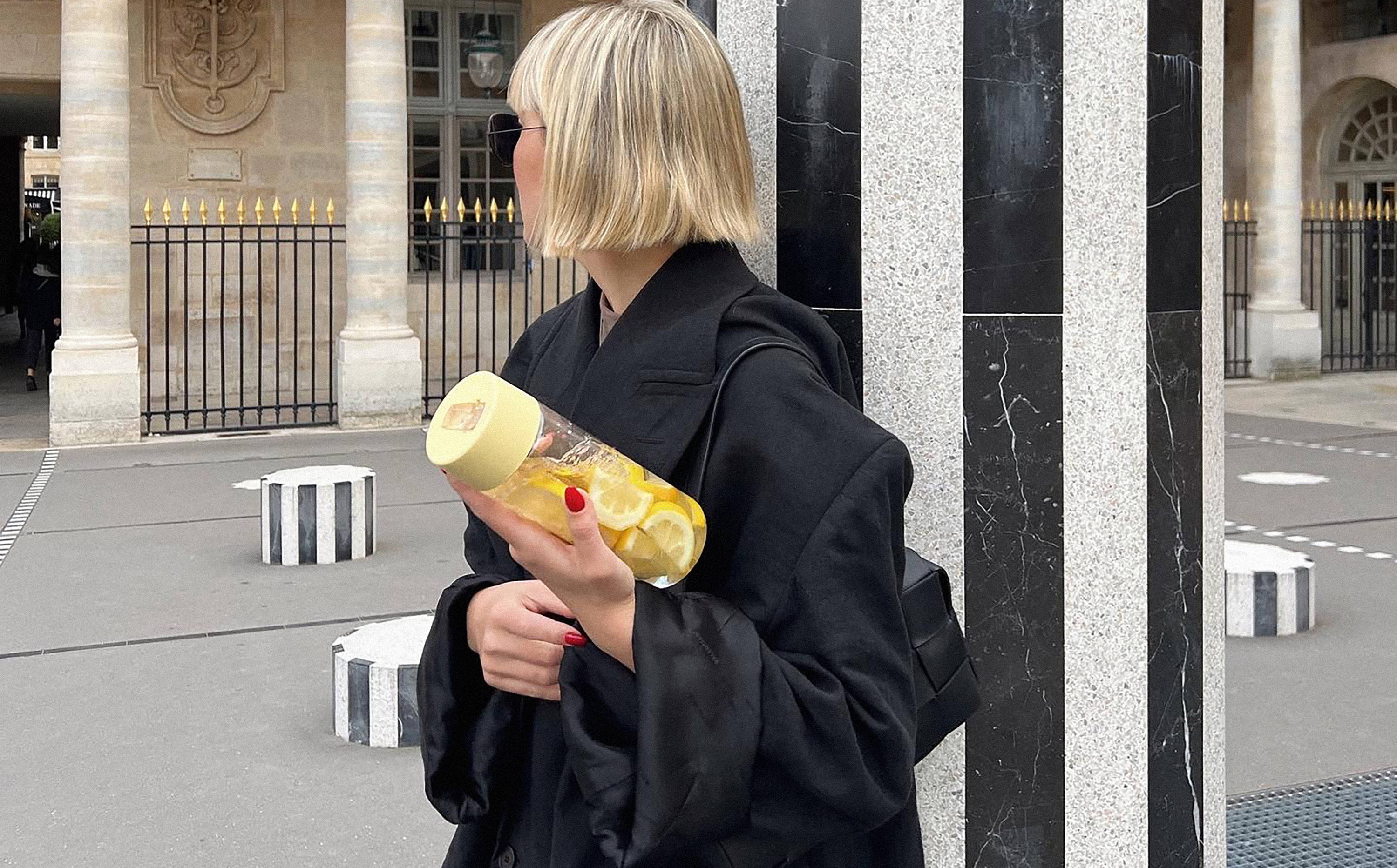 Violet Grace holding a 25oz / 740ml Original Reusable Bottle in with Buttermilk straw lid