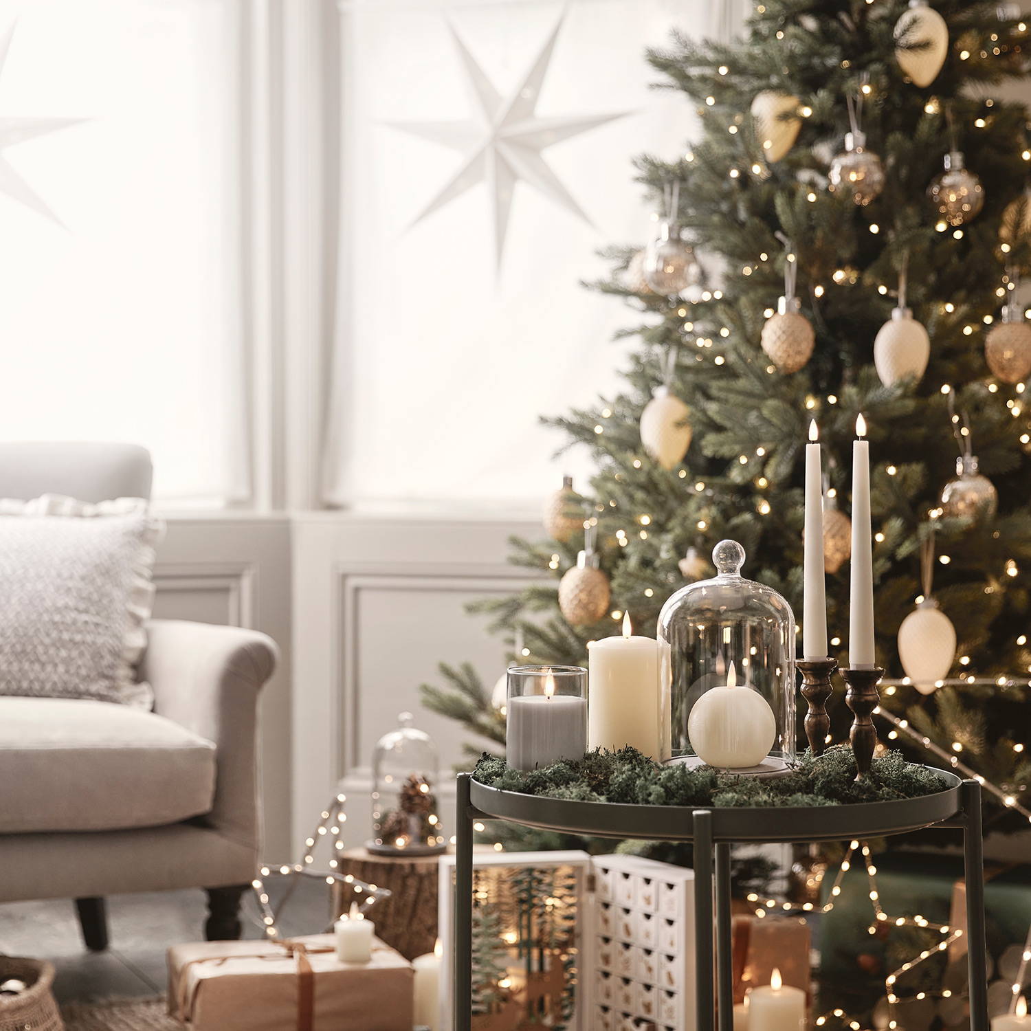 A Christmas tree in the background with LED candles and star lights as decorations.