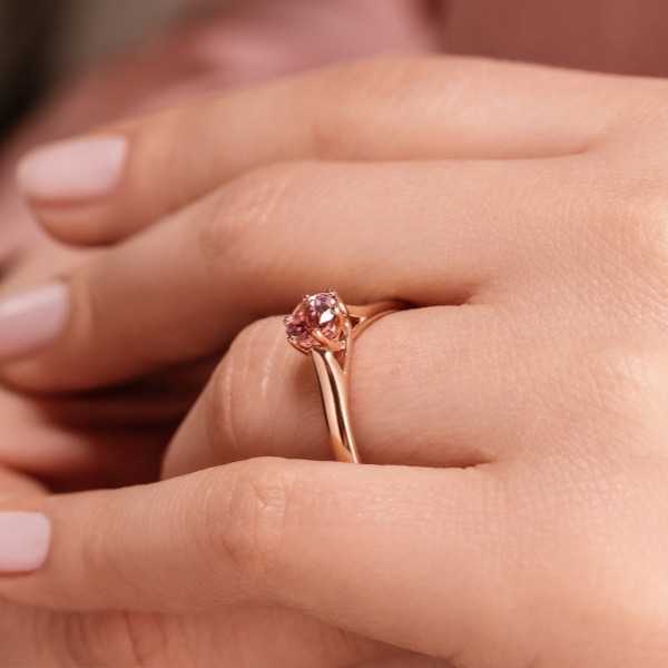 elegant solitaire engagement ring in yellow gold with round pink champagne sapphire center stone