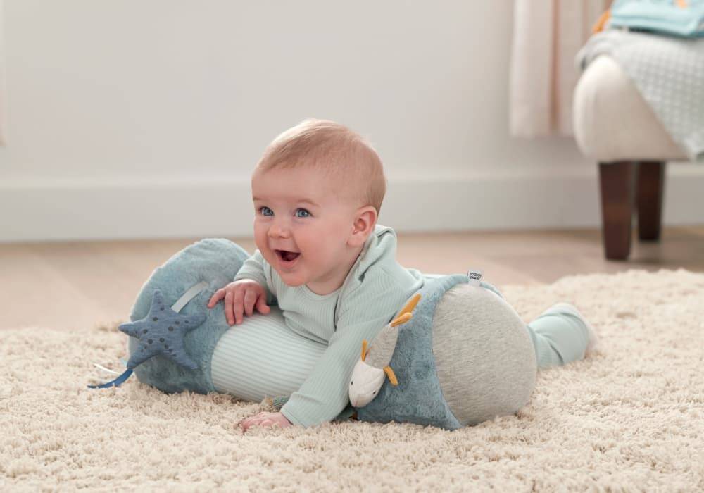 Smiling baby on a blue tummy time toy