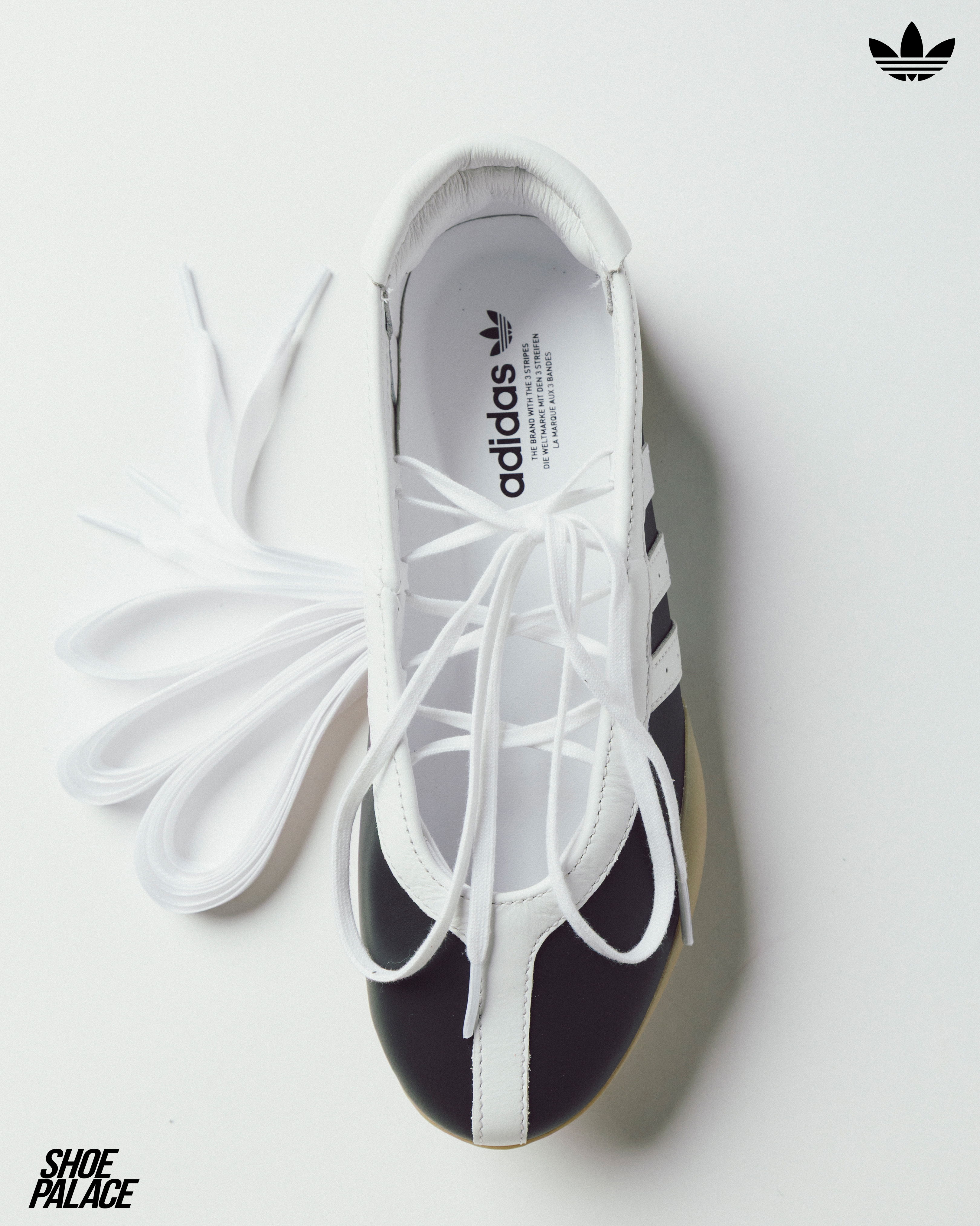 Adidas shoe with black and white design, laces untied, top view.