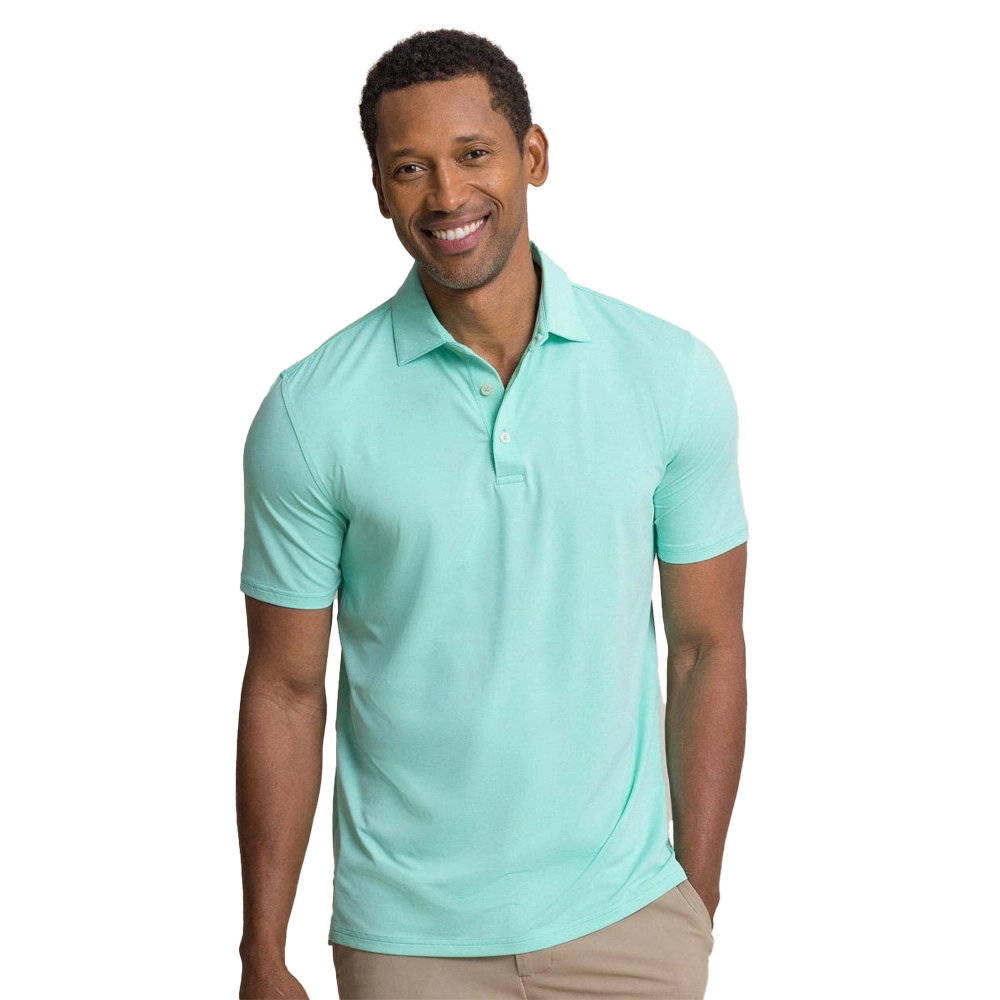 Smiling man wearing a mint green polo shirt and beige pants.