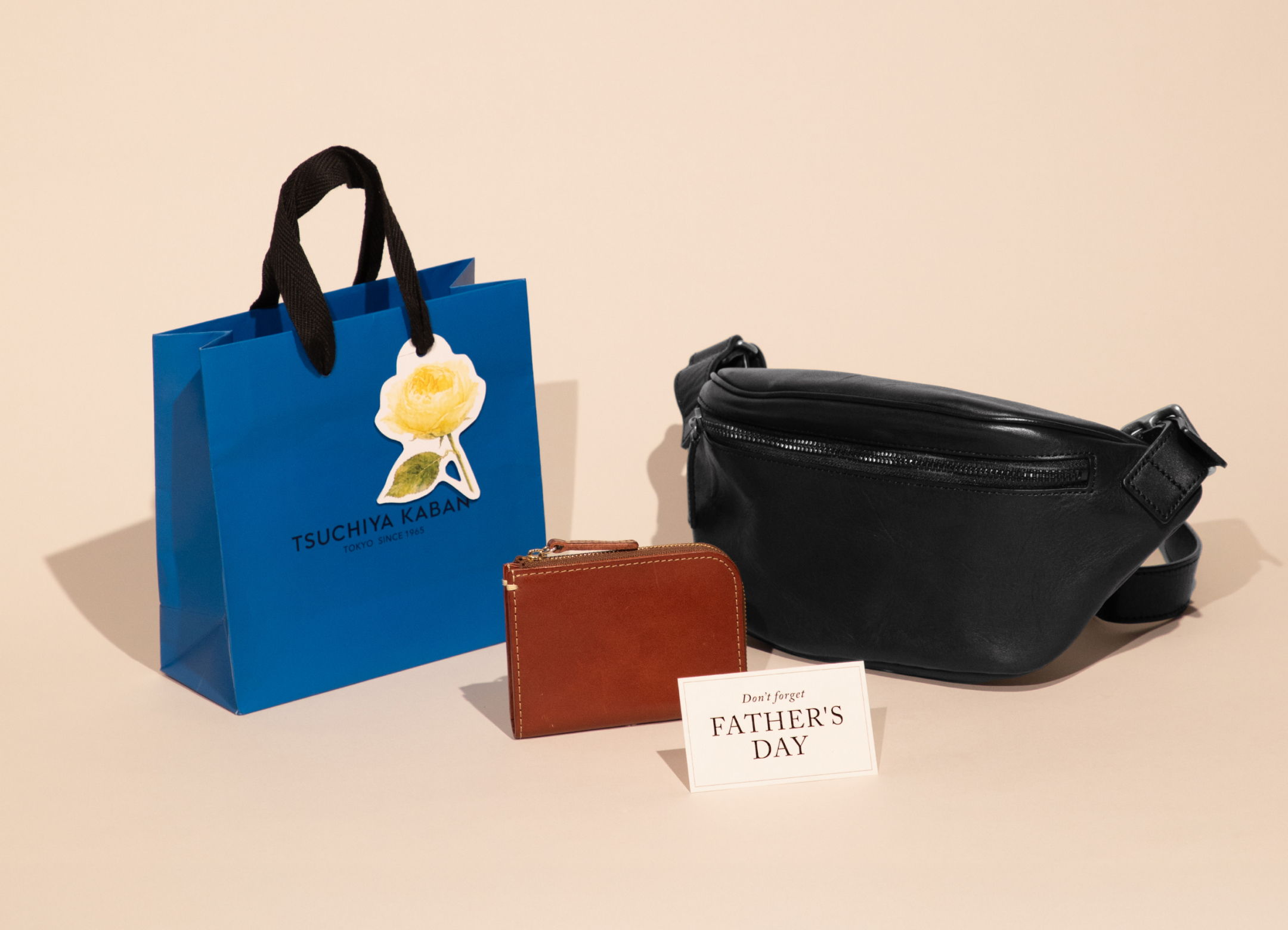 A blue bag, a brown wallet, and a black fanny pack on display.