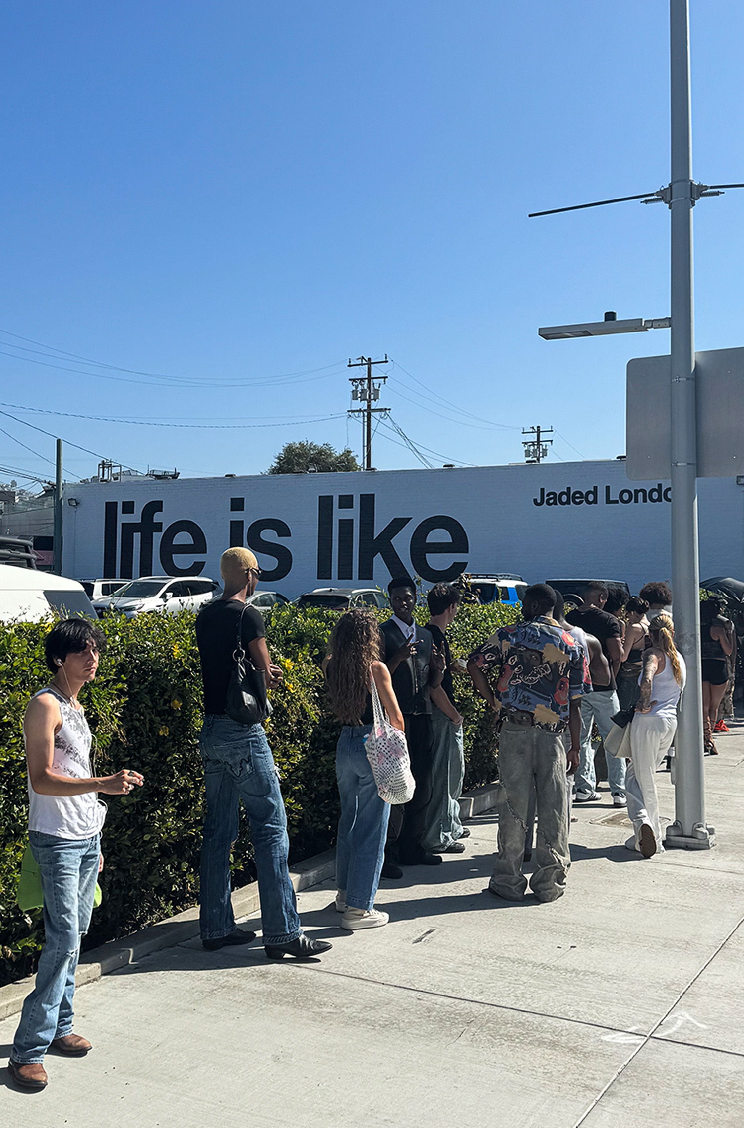 People waiting in line near a wall with 